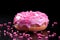 pink frosted donut on black background