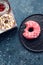 Pink frosted donut on dark background