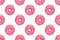 Pink frosted donuts with white sprinkles on white background. Seamless pattern