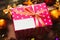 Pink gift box with blank card under Christmas tree