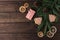 Pink gift box with cones, spruce branches, cookies shaped christmas tree and dry slices of citrus on a dark wooden background.