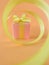 Pink Gift box at the end of the spiral yellow ribbon, orange background. vertical.