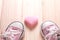 Pink girl`s sneakers with pink hearts on a wooden floor,