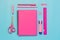 Pink girlish school supplies, notebooks and pens on punchy blue. Top view, flat lay. Copy space.