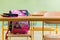 Pink girly school bag and pencil case on a desk in an empty classroom. First day of school.