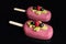 Pink glazed berry gelato ice cream on stick with raspberry, pistachio sponge and black currants
