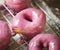 Pink glazed donuts on a cooling rack