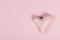 PInk glossy heart shaped stone on a pink background with space for copy