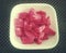 A pink glossy ripe watermelon pieces in a bowl