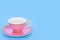 Pink and Gold Porcelain Tea Cup on Blue Background