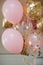 Pink and golden balloons with text `it`s a girl` gender reveal party.