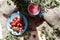 Pink gooseberries on a blue saucer with a mug of Morse, close-up, top view