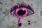 Pink graffiti tearful eye on a wall