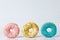 Pink, green and blue donuts on polka dots background
