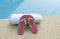 Pink and green shoes white towel swimming pool