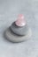 Pink Gua Sha facial massage and face care tool. Rose Quartz gua sha mashroom shape stone on grey stone pyramid on