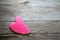 Pink guasha heart for face and body massage. Gua sha massage jade, Chinese medical traditional tool on wooden background.
