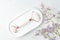 Pink Guasha massage tools in concrete tray on marble background. Rose quartz jade roller. Skin care at home, anti-aging and