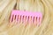 Pink hairbrush on wig in blond color