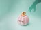 Pink halloween fairy tale pumpkin with golden petiole and eyelashes with witch dark shadow arm. Green mint background color.