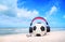 Pink headphones,football on blue sky and beach background.