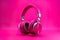 Pink headphones isolated on viva magenta background. Wireless and wired headset with noise cancelling.