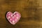 Pink heart of handwork on a wooden background