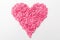 Pink heart made of many smaller hearts on a white background