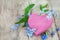 pink heart shape made of wood with forget-me-not flowers on a wooden background