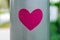 Pink heart-shaped sticker stuck on lamppost