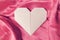 Pink heart, Valentine. A heart made of paper, origami, lies on a silk background.