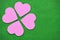 Pink hearts arranged like flower petals. Placed on a moist green