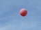 Pink Helium Balloon Flying with Blue Sky and White Clouds in Background