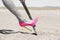 Pink high heel shovel digging in desert dirt