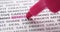 Pink highlighter pen marks words remote working. Macro shot, selective focus