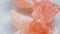 Pink himalaya salt pieces close-upon a light marble background.Pink crystal salt