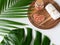 Pink Himalayan salt and towel on wooden plank, monstera and palm leaves