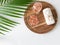 Pink Himalayan salt and towel on wooden plank and palm leaf