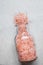 Pink Himalayan Salt in Vintage Glass Bottle Spilled on White Marble Stone Tabletop. Wellness Spa Healthy Diet Nutrition Ayurveda