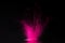 Pink holi powder explosion on black