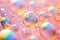 Pink holographic bubbles floating on the soft colorful abstract background in beautiful vivid tones.