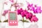 Pink hygrometer on white table with orchids on the background