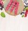 Pink Ice cream pops with summer berries and rmint leaves on white wooden background, close up