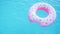 Pink inflatable donut ring floating in clear blue swimming pool. Top view. Summer colorful background. Vacation, relax