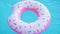 Pink inflatable donut ring floating in clear blue swimming pool. Top view. Summer colorful background. Vacation, relax