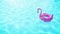 Pink inflatable flamingo floating on blue water in swimming pool for summer holiday and travel concept with space for text