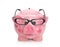 Pink isolated piggy bank with glasses on white.