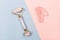 Pink jade roller and gua sha tool on pastel background