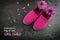 Pink kid shoes and flowers on a dark slate background, text Day