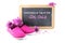 Pink kid shoes and flowers in front of a writing blackboard with